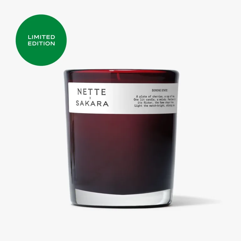 Sakara x Nette Serene State Scented Candle in deep red translucent glass vessel with white label reading Serene State and Limited Edition badge displayed.