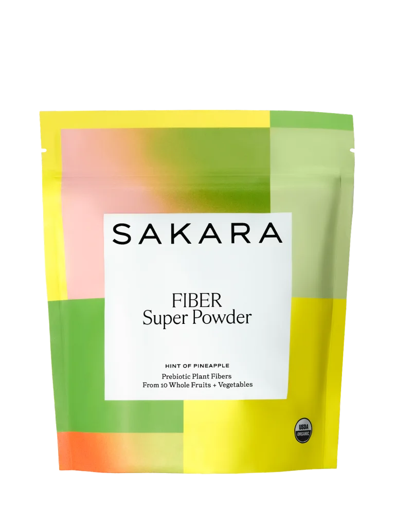 Sakara Fiber Super Powder in colorful resealable pouch labeled Hint of Pineapple, prebiotic plant fibers from 10 whole fruits and vegetables, displayed on white background
